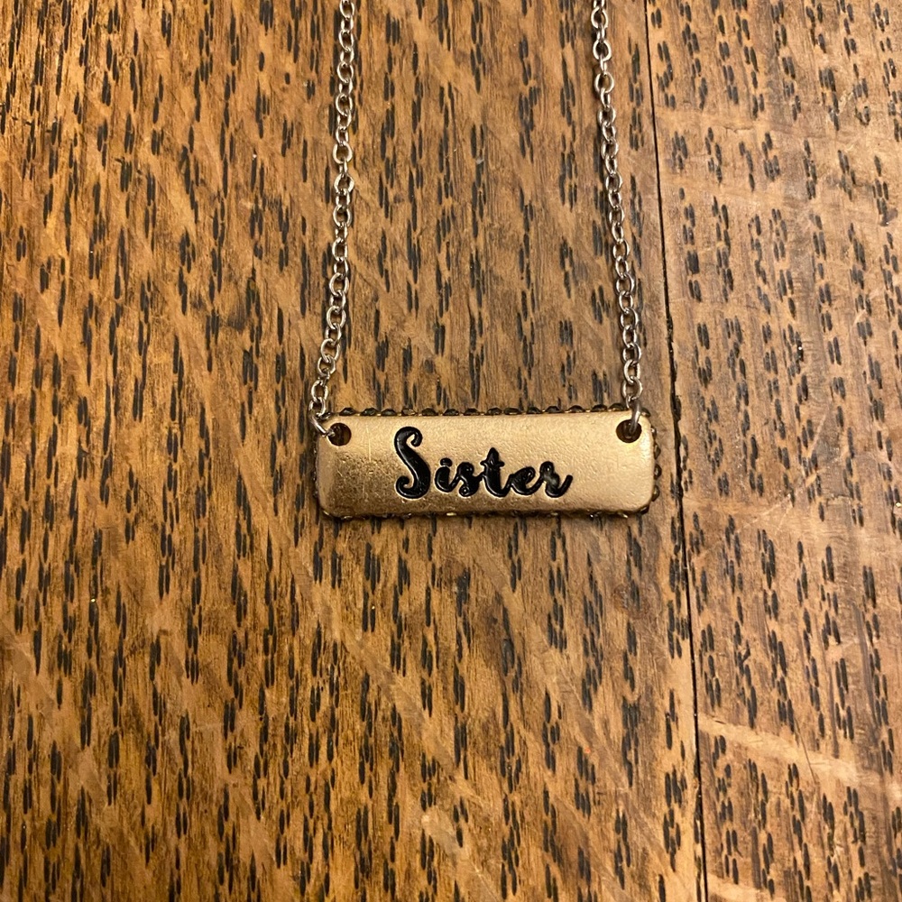 New silver & gold reversible necklace. One side says sister & the other hearts